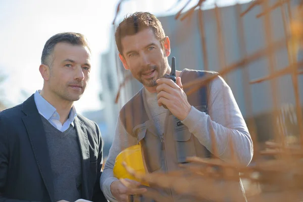 Bouwvakker Walkie Talkie Achter Stapel Rebars — Stockfoto