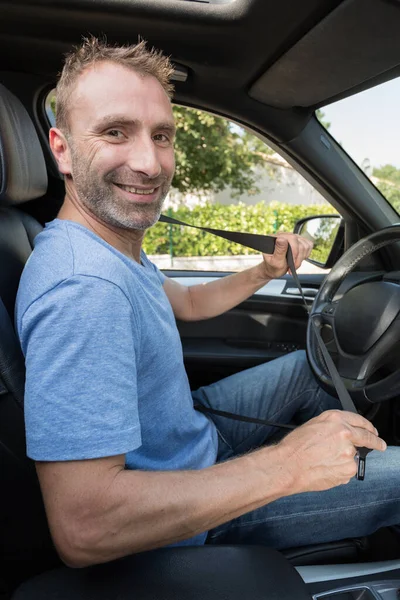 幸せな男性ドライバー車の中で安全ベルトを締結 — ストック写真