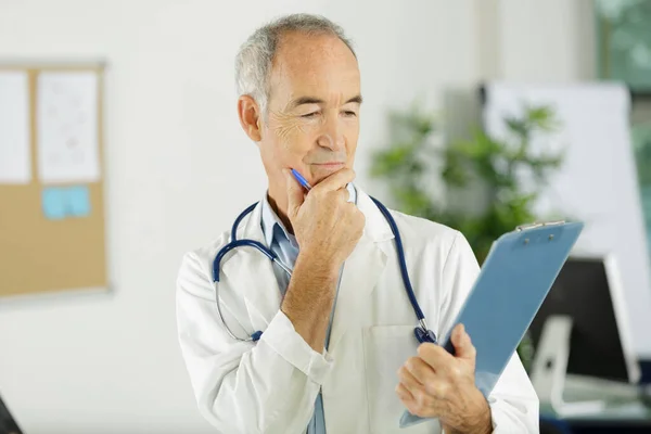 Senior Doctor Looking Clipboard Stock Picture