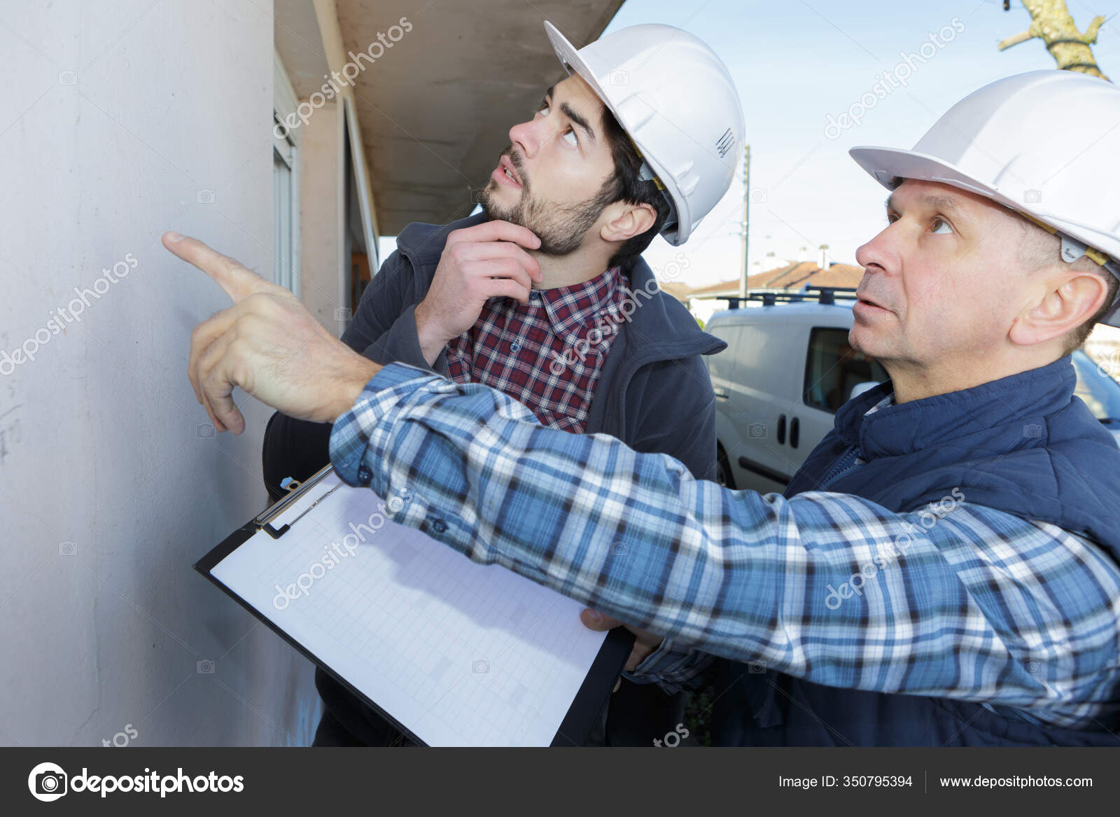 Two Contractors Clipboard Assessing Exterior Wall Stock Photo by