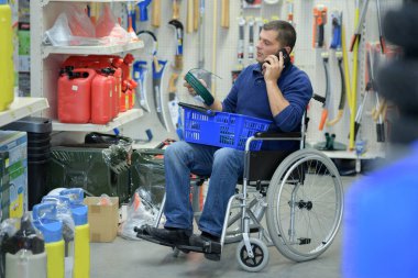 man in wheelchair shopping in hardware store clipart