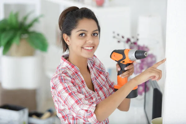 Jong Gelukkig Vrouw Boren Een Muur Thuis — Stockfoto