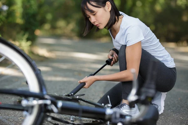 Женщина Накачивает Велосипедную Шину — стоковое фото