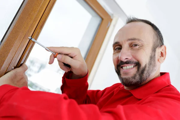 Smiling Man Fixing Window Using Screwdriver — Stock Photo, Image