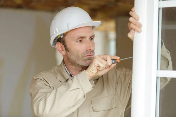 Lächelnder Mann Fixiert Einen Fenstergriff — Stockfoto