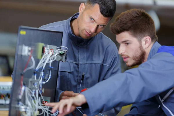 Techniker Und Lehrling Reparieren Fernseher Wand Montiert — Stockfoto