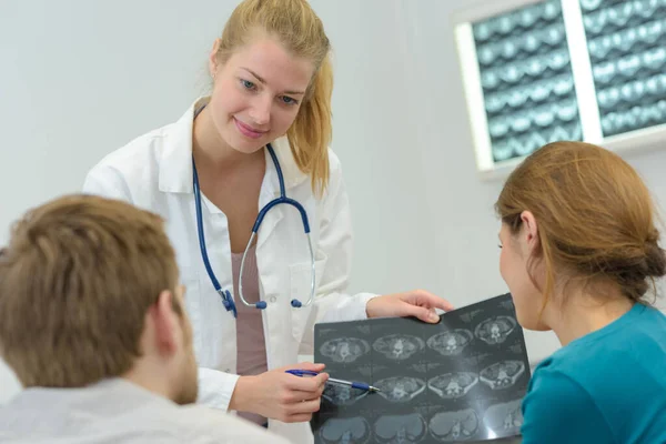 Ärztin Zeigt Jungen Paar Röntgenbild Klinik — Stockfoto