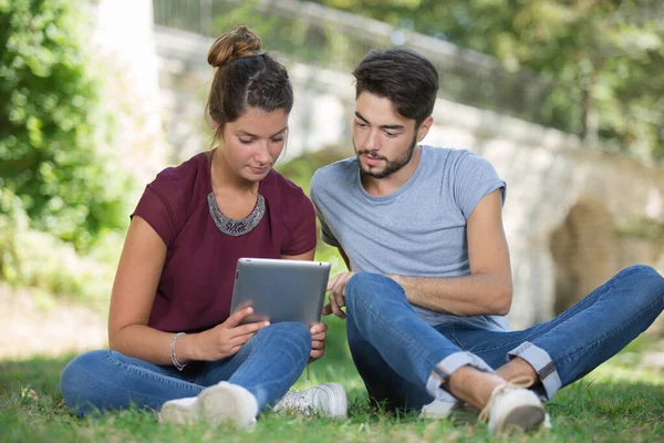 Üniversite Öğrencileri Kampüs Çimlerinde Tablet Kullanıyorlar — Stok fotoğraf