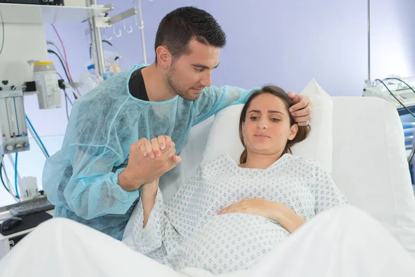 Woman in labor, partner holding her hand