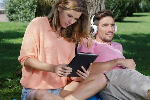 Pareja Aire Libre Utilizando Tableta Escuchar Los Auriculares — Foto de Stock