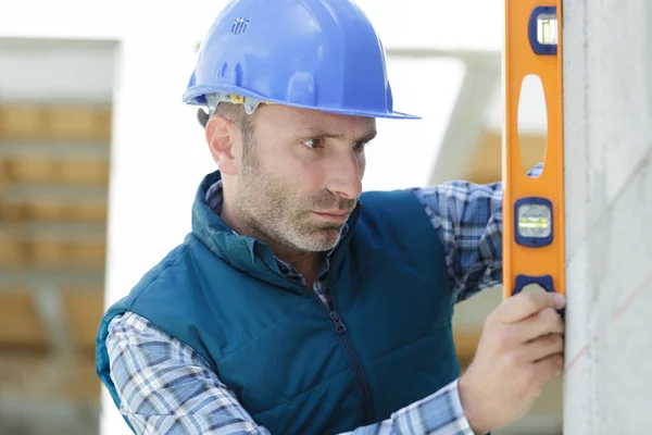 Mann Der Das Niveau Einer Bauwand Überprüft — Stockfoto