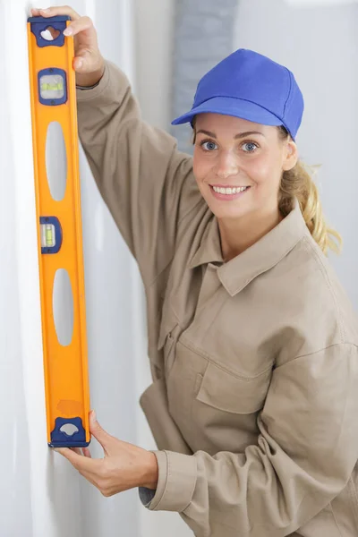 Woman Worker Leaning Spirit Level Wall — Stock Photo, Image