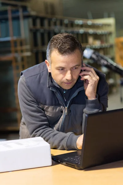 Porträt Eines Mannes Mit Laptop Beim Telefonieren — Stockfoto