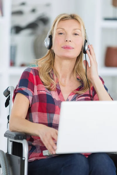 Kadın Tekerlekli Sandalyede Müzik Dinlerken Dizüstü Bilgisayar Kullanıyor — Stok fotoğraf