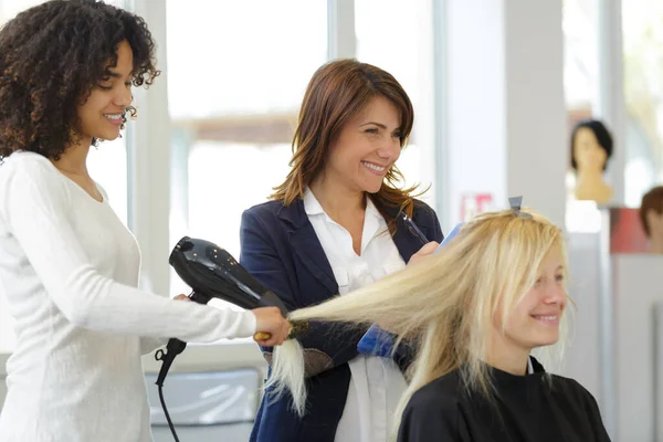 Kadeřnické Učeň Žehlit Klientům Vlasy — Stock fotografie