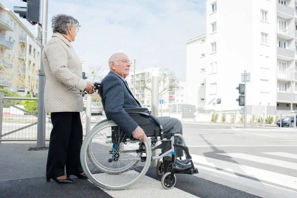 Senioren Paar Rolstoel Kruising Weg — Stockfoto