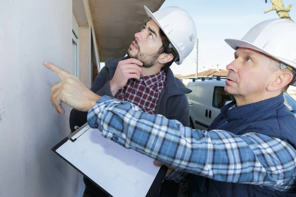 Twee Aannemers Met Klembord Dat Buitenwand Beoordeelt — Stockfoto