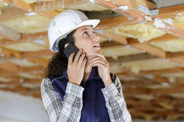 Construtor Feminino Usando Smartphone Para Comunicar Problema Com Teto — Fotografia de Stock