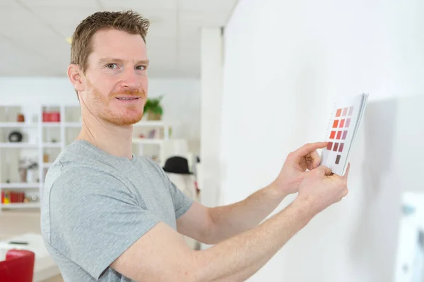 Man Hålla Färg Färgprover Upp Till Väggen — Stockfoto