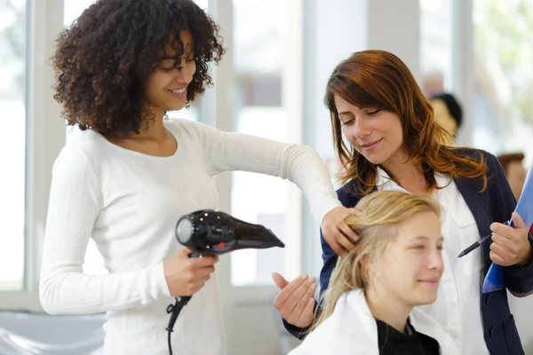 女性は見習い美容師による洗髪を受けています — ストック写真