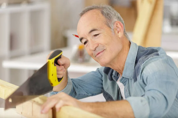 Senior Man Die Binnen Hout Zaagt — Stockfoto