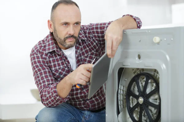 Man Met Behulp Van Tablet Wasmachine Repareren — Stockfoto