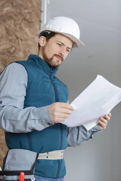 Tradesman Wearing Toolbelt Studying Plans — Stock Photo, Image