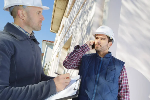 Architect Met Plannen Buiten Het Nieuwe Huis Praten Mobiele Telefoon — Stockfoto