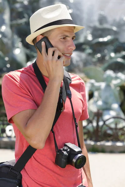 Joven Turista Masculino Con Cámara Hablando Smartphone — Foto de Stock