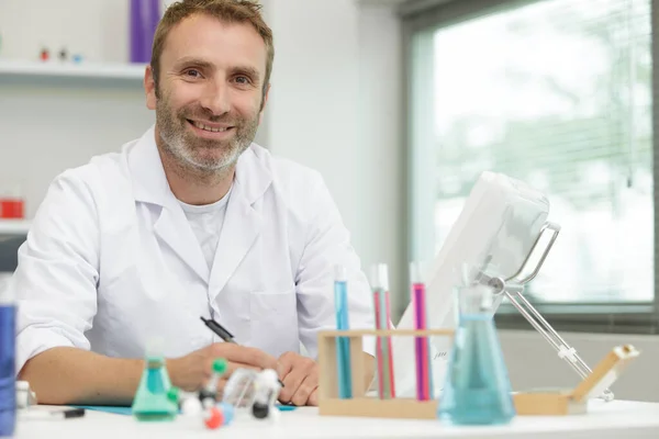 Šťastný Mužský Vědec Drží Baňku Modrou Tekutinou — Stock fotografie