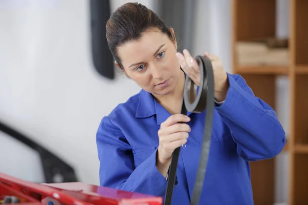 車の部品を扱う整備士の女性は — ストック写真