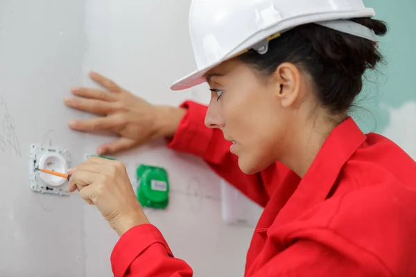 Vrouwelijke Elektricien Werkt Aan Stopcontact — Stockfoto