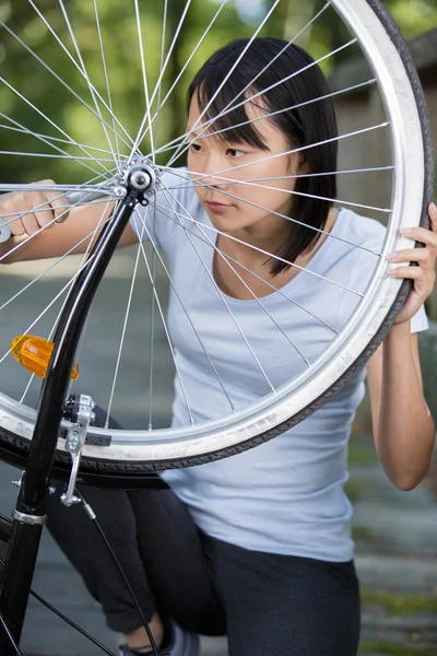 Молодая Женщина Гаечным Ключом Ремонтирует Велосипедное Колесо — стоковое фото
