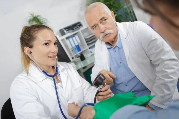 患者の血圧を測定する医師と看護師 — ストック写真