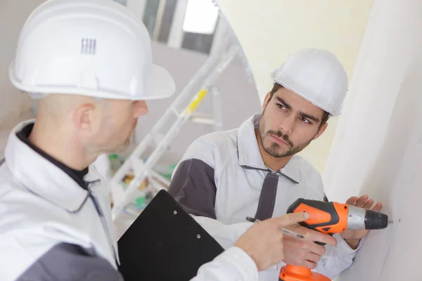 Giovane Lavoratore Utilizzando Trapano Accigliato Collega — Foto Stock