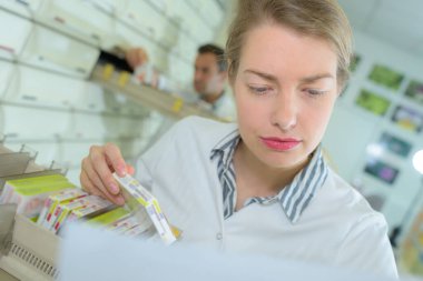 pharmacist searching for medication on pharmacy shelves clipart
