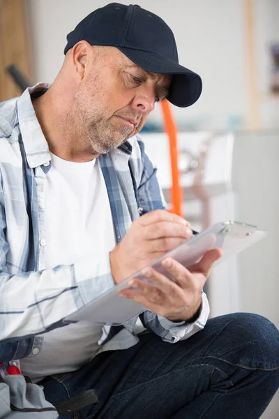 Senior Handelaar Schrijft Een Klembord — Stockfoto