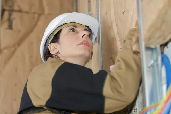 Construtor Feminino Colocando Parede Isolamento — Fotografia de Stock
