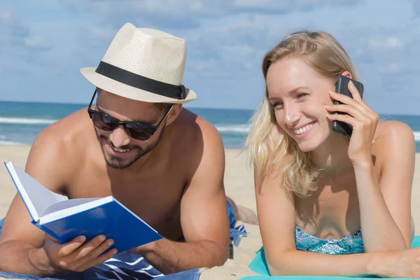 Junges Paar Entspannt Strand Mit Buch Und Telefon — Stockfoto
