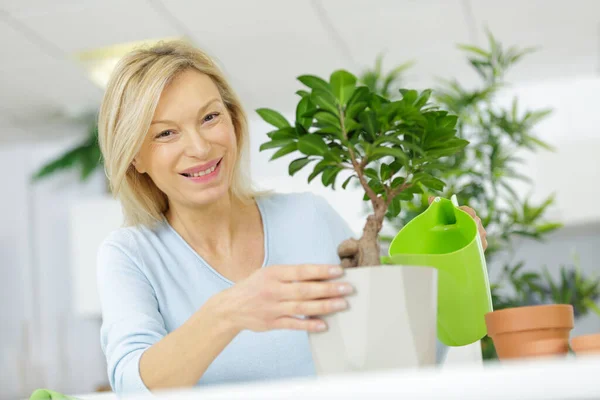 幸せな女性成熟した散水盆栽 — ストック写真