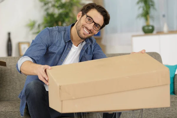 Man Öppnar Ett Paket Från Webbutik Hemma — Stockfoto