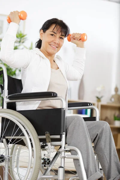 ダンベル付きの車椅子のシニアスポーツ女性は — ストック写真
