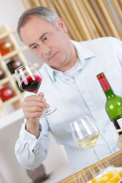 Yaşlı Bir Adam Bardaktaki Kırmızı Şaraba Bakıyor — Stok fotoğraf