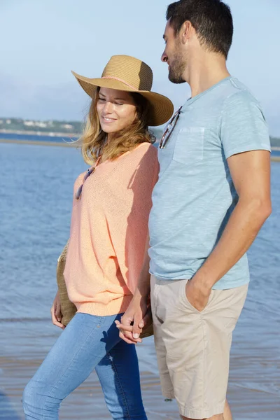 男と女が手を取り海岸を歩き — ストック写真