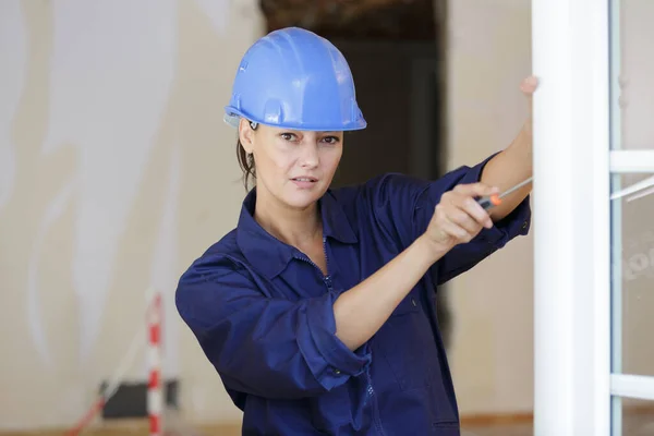 Female Builder Screwdriver Tightens Fixing Window — Stockfoto
