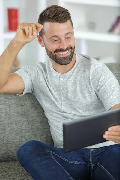 Przystojny Szczęśliwy Człowiek Patrząc Tablet Kanapie — Zdjęcie stockowe
