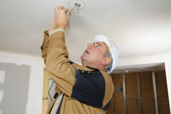 Arbeiter Mann Wechselt Glühbirne — Stockfoto