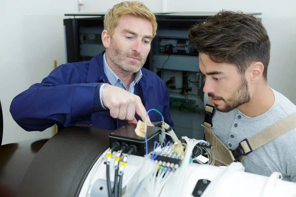 Giovane Elettricista Maschio Con Mentore Alla Ricerca Installazione — Foto Stock