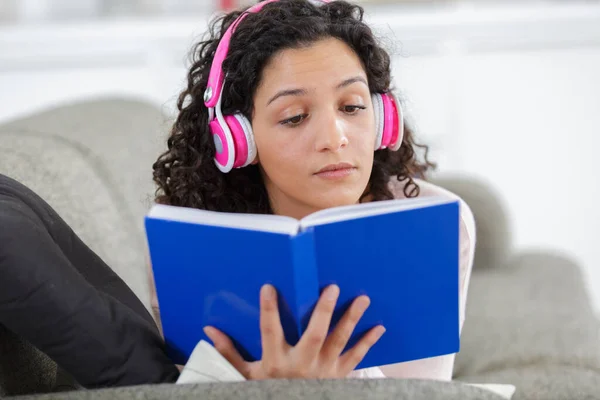 Mujer Sonriente Auriculares Con Libro Sentado Casa —  Fotos de Stock