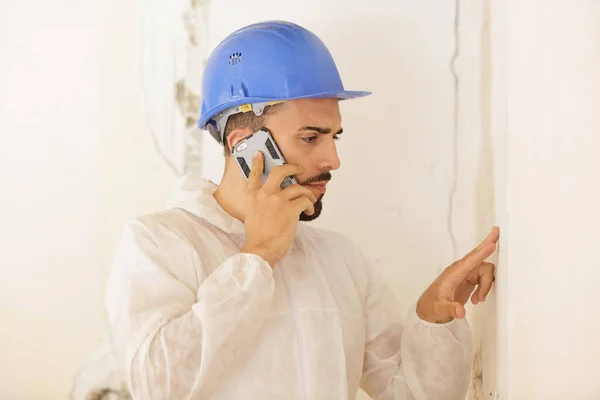 Constructor Inspeccionando Pared Mientras Habla Por Teléfono Celular — Foto de Stock